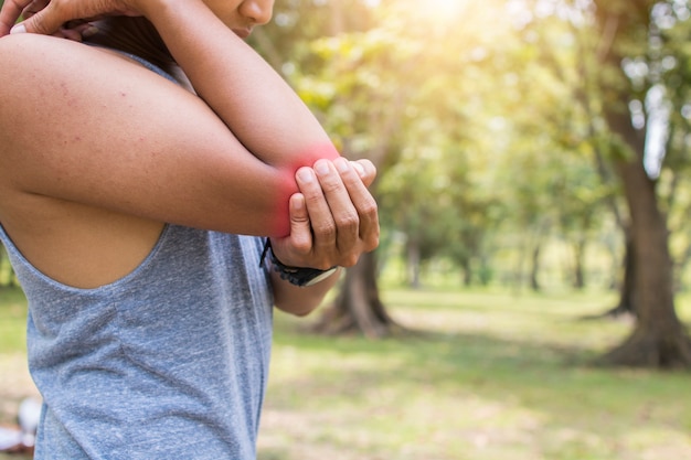 L&#39;homme a une blessure au coude et la douleur alors que travailler dehors dans le parc