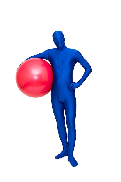 Homme bleu mystérieux en costume bleu avec ballon de pilates rouge