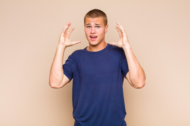 Homme blond criant avec les mains en l'air