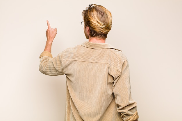 Homme blond debout et pointant vers l'objet