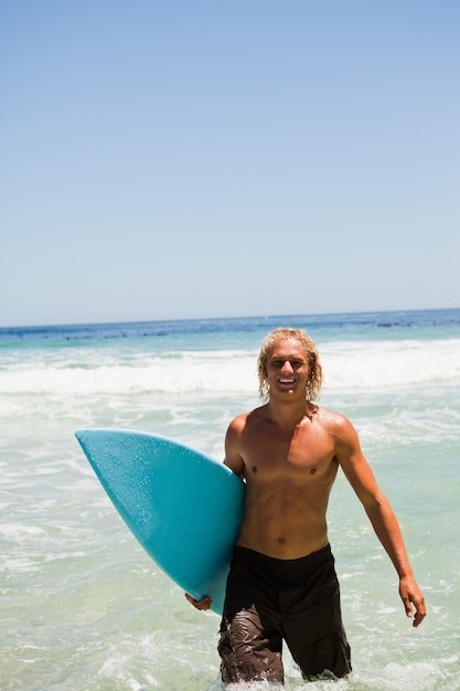 Homme blond marchant dans l&#39;eau tout en montrant un sourire rayonnant