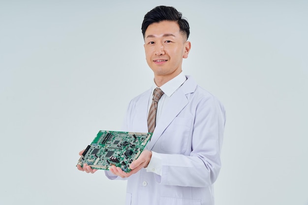 Un homme en blouse blanche avec un circuit électronique