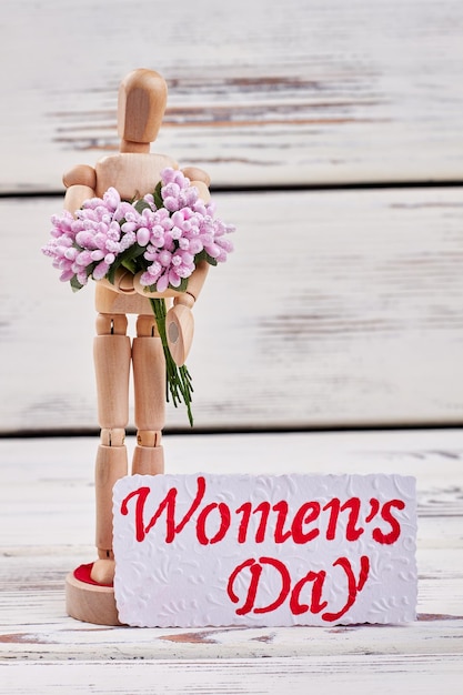 Homme en bois avec bouquet Salutation pour chères femmes