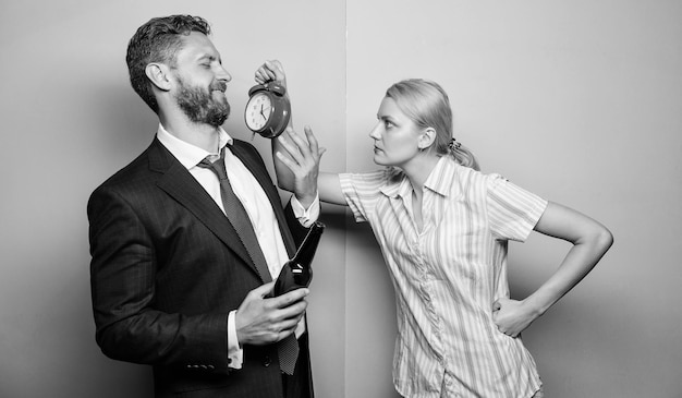 Homme boisson alcoolisée vin femme montrer l'heure au réveil femme se demandant pourquoi le mari est venu si tard famille couple problèmes de routine dans les relations psychologie familiale vie malheureuse