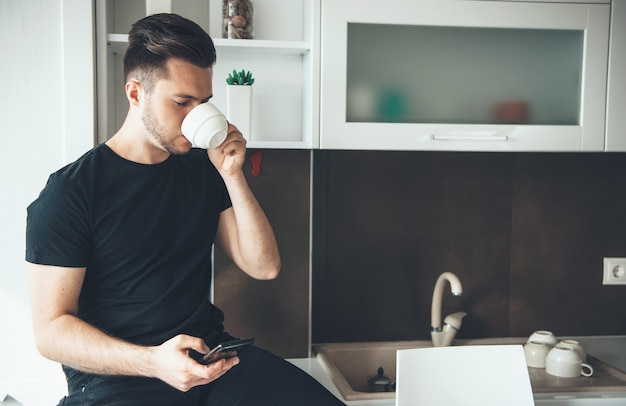 L'homme boit un café tout en discutant au téléphone