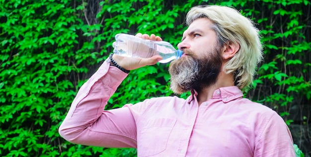 L'homme boit de l'eau. Mode de vie sain. Une bouteille d'eau potable pour homme assoiffé. Notion d'hydratation.