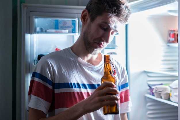 L'homme boit l'ours du réfrigérateur la nuit b