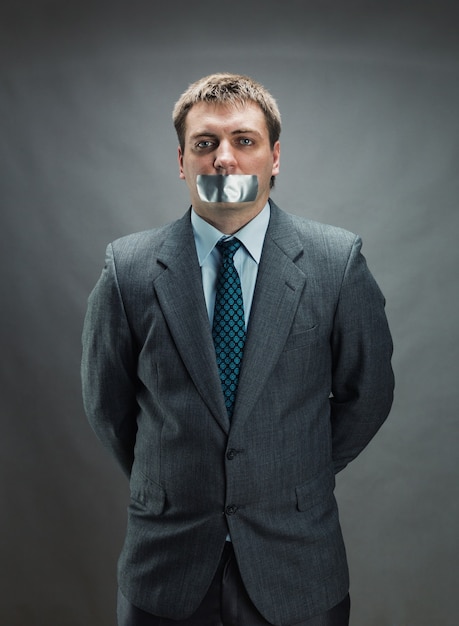 Photo homme avec la bouche couverte de ruban adhésif