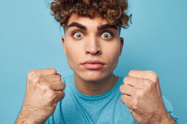 Homme bouclé dans un tshirt sur un fond coloré posant