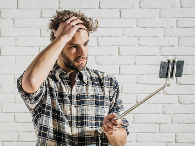 Un homme bouleversé utilise un bâton à selfie