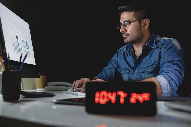 Homme bourreau de travail fait des heures supplémentaires tard dans la nuit au bureau