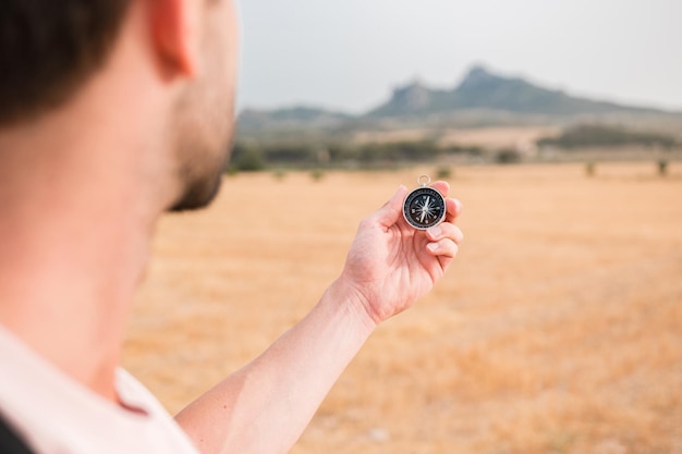 Homme avec une boussole dans un paysage montagneux