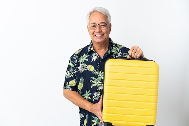 Homme brésilien d'âge moyen isolé sur fond blanc en vacances avec valise de voyage