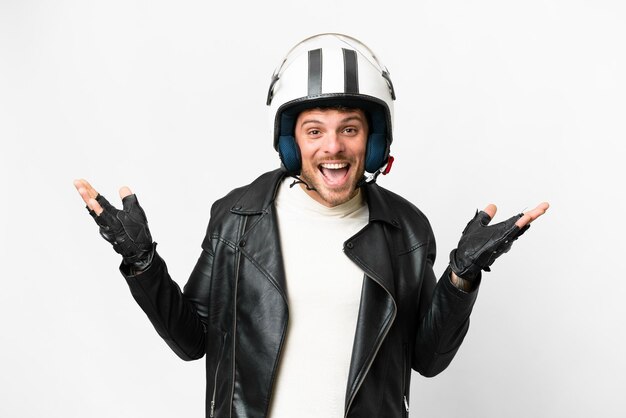 Homme brésilien avec un casque de moto sur fond blanc isolé avec une expression faciale choquée