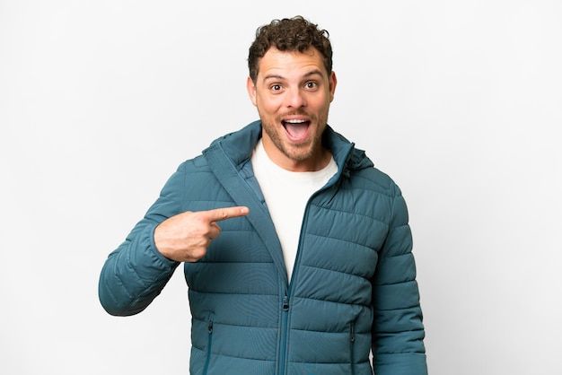 Homme brésilien sur fond blanc isolé avec une expression faciale surprise