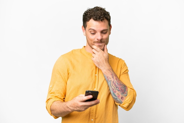 Homme brésilien sur fond blanc isolé pensant et envoyant un message