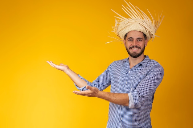 Homme brésilien portant des vêtements typiques pour la Festa Junina pointant