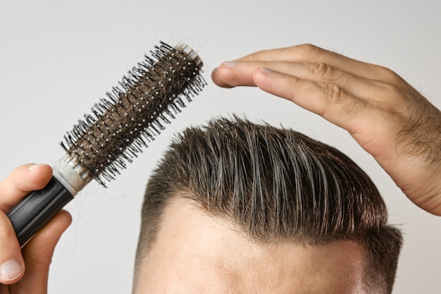 Homme avec une brosse coiffant ses cheveux