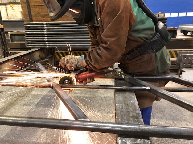 Un homme broyant du métal dans une usine