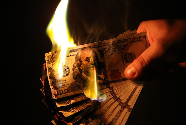 L'homme brûle de l'argent Dollars photo Concept de corruption cupide Idée de pot-de-vin Taux d'inflation Croissance des prix
