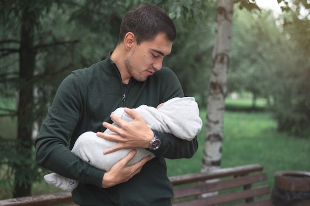 Homme brune avec bébé nouveau-né dans les bras dans le parc
