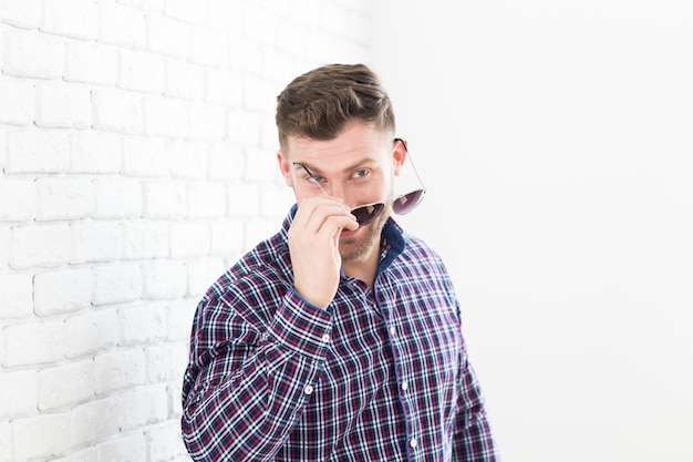 Homme brutal avec une barbe et des lunettes de soleil