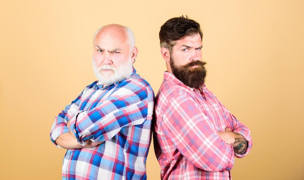 Homme brutal soins de la barbe homme mode à carreaux salon de coiffure et salon de coiffure père et fils famille conflit générationnel jeunesse vs vieillesse comparer retraite deux hommes barbus senior et mature