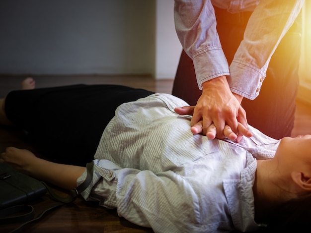 Un homme de bureau bénévole utilise une pompe à main sur la poitrine pour les premiers soins en cas d&#39;urgence