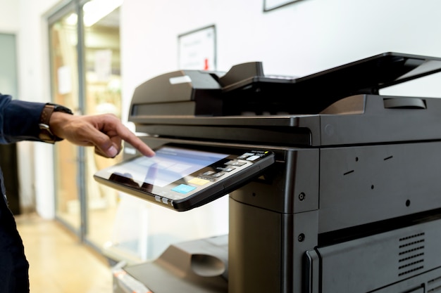 Homme de bussiness Main appuyez sur le bouton sur le panneau de l&#39;imprimante, imprimante scanner laser bureau copie machine fournit le concept de départ.
