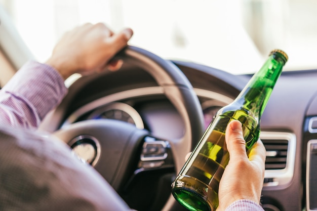 Homme buvant de l&#39;alcool en conduisant la voiture