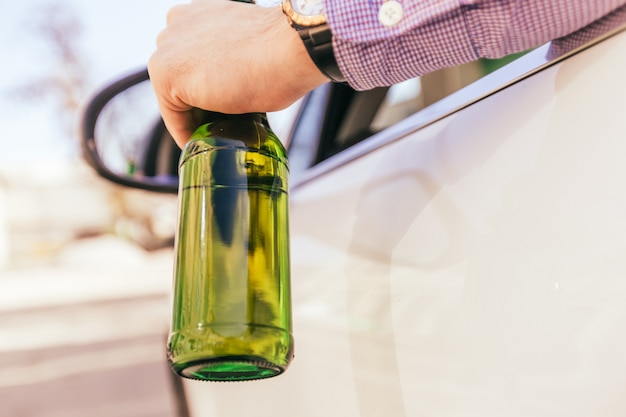 Homme buvant de l'alcool en conduisant la voiture