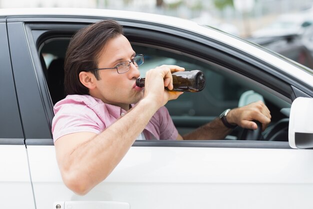 Homme buvant de la bière en conduisant