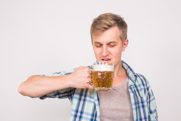 Homme buvant de la bière. Heureux jeune homme tenant une chope de bière.