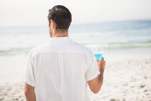 Homme buvant un cocktail sur la plage