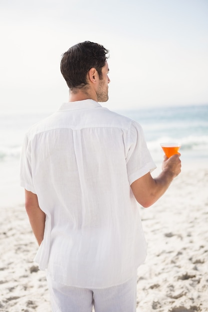 Homme buvant un cocktail sur la plage