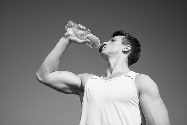 Homme buvant de l'eau de la bouteille aux beaux jours