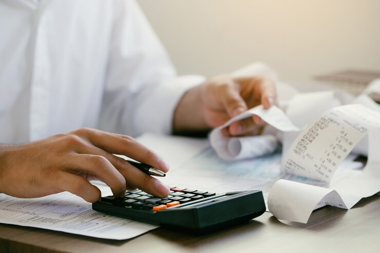 Photo l'homme calcule les factures domestiques à la maison l'homme utilise une calculatrice vérifiant le solde et les coûts au bureau