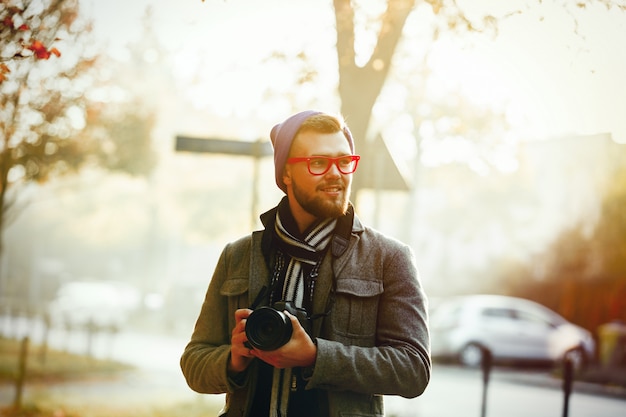 Homme avec caméra dans l'allée de la saison d'automne