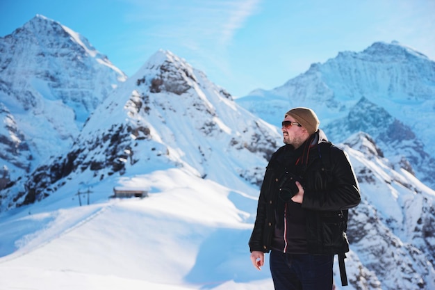 Homme avec caméra à la montagne Mannlichen en hiver Alpes Suisses