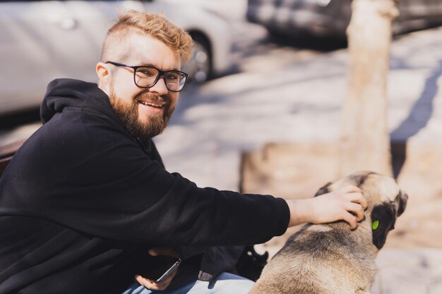 Homme caressant un concept d'animal de compagnie et de chien de rue sans abri