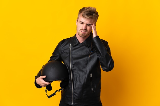 Homme avec un casque de moto isolé sur fond jaune avec des maux de tête