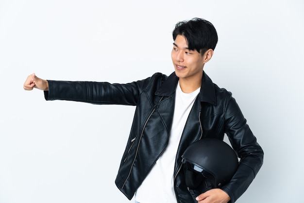 homme avec un casque de moto posant isolé contre le mur blanc