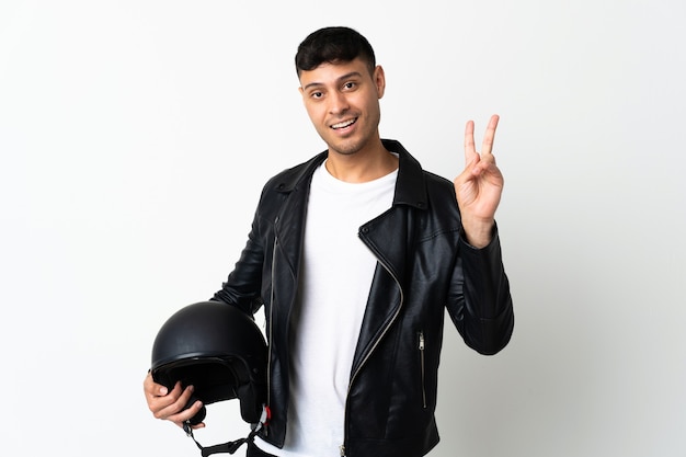 Homme avec un casque de moto souriant et montrant le signe de la victoire