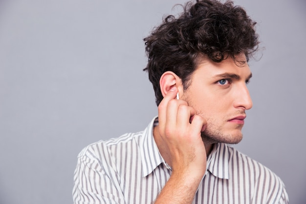 Homme avec un casque sur mur gris