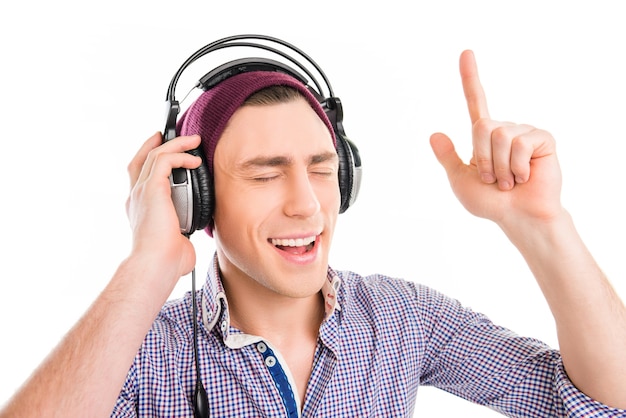 Homme en casquette et casque d'écoute de la musique et des gestes avec le doigt levé