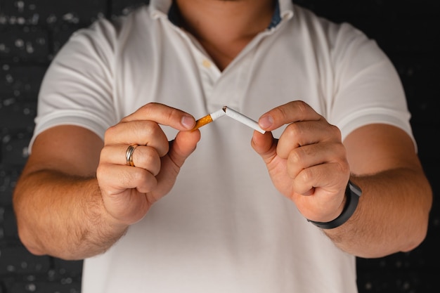 Homme cassant la cigarette dans les mains abandonnant la mauvaise habitude