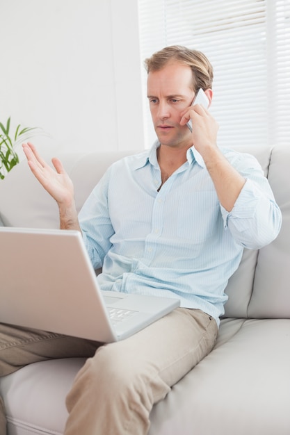 Homme Casual à l&#39;aide d&#39;un ordinateur portable sur le canapé