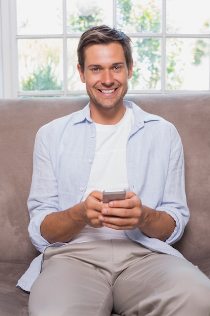 Homme Casual, lecture de SMS sur le canapé