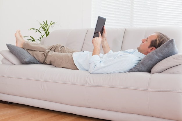 Homme Casual avec tablette sur le canapé