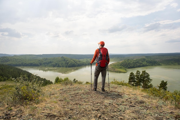 Photo homme caucasien actif en randonnée dans les montagnes avec des sacs à dos et des bâtons de randonnée appréciant leur aventure